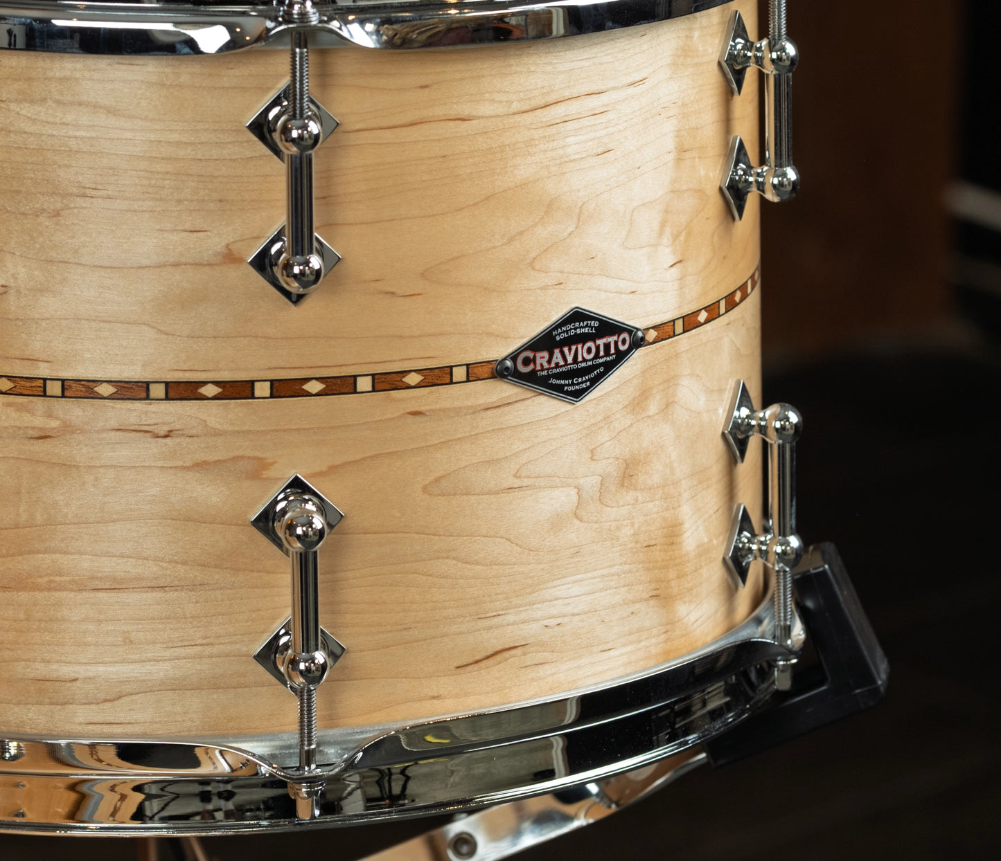 Close-up of a maple tom with walnut inlays  'Craviotto' branding.