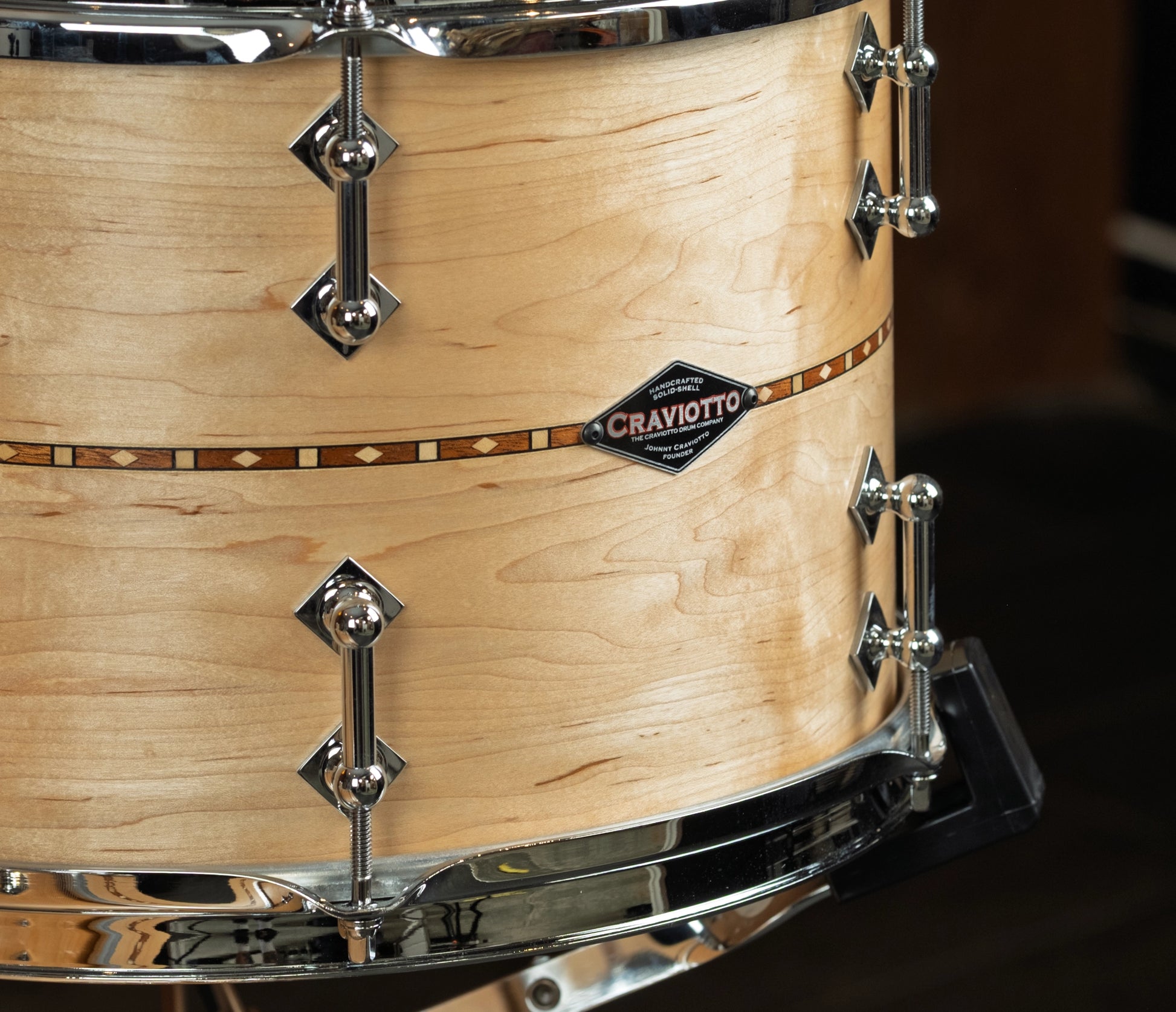 Close-up of a maple tom with walnut inlays  'Craviotto' branding.