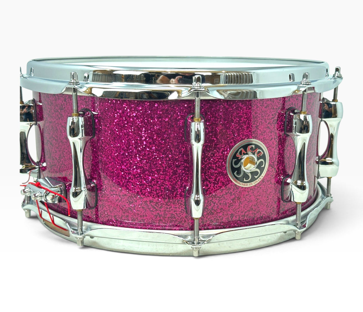Sakae Evolved 14" x 6.5" Snare Drum in Magenta Sparkle – angled shell and hardware view