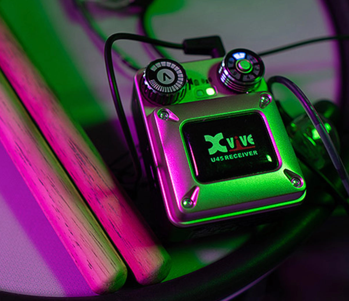 XVIVE U45 belt-pack receiver with earphone cable in coloured stage lighting
