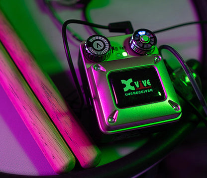 XVIVE U45 belt-pack receiver with earphone cable in coloured stage lighting